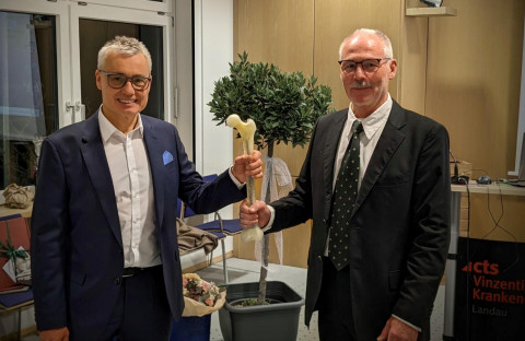Dr. Werner Jung (rechts) übergibt Dr. Dirk Gehm als „Staffelstab“ einen künstlichen Oberschenkelknochen mit einem Osteosynthese-Nagel